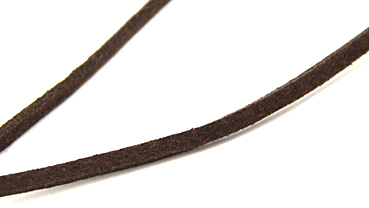 Kette mit Alcantaraband und Messingblatt auf Holzplatte